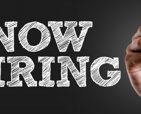 Hand writing the text: Now Hiring